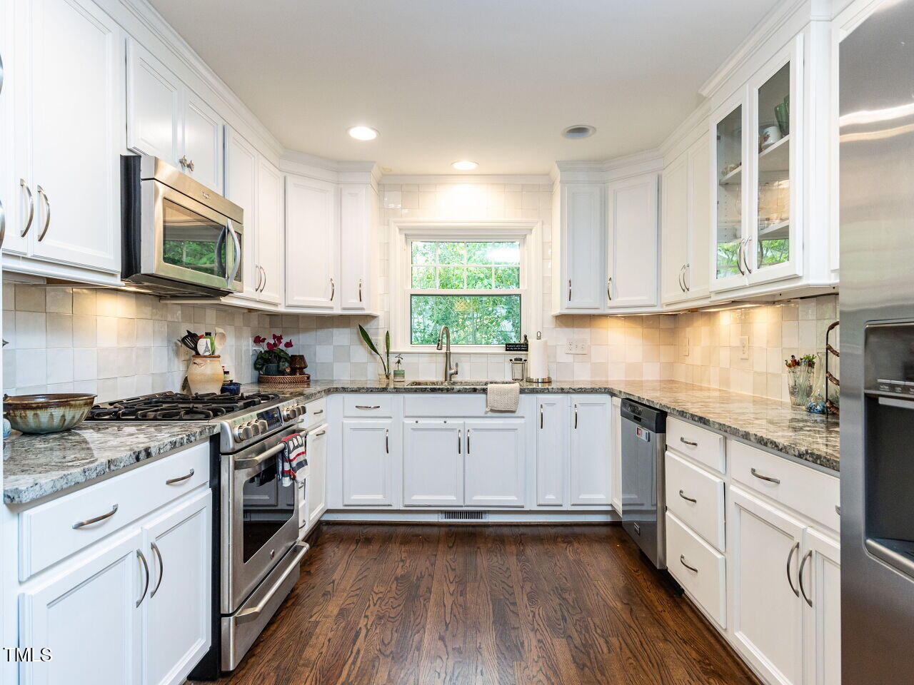 713 Macon Place Raleigh, NC 27609 - Photo 8 of 36 a kitchen with granite countertop cabinets stainless steel appliances a sink and window