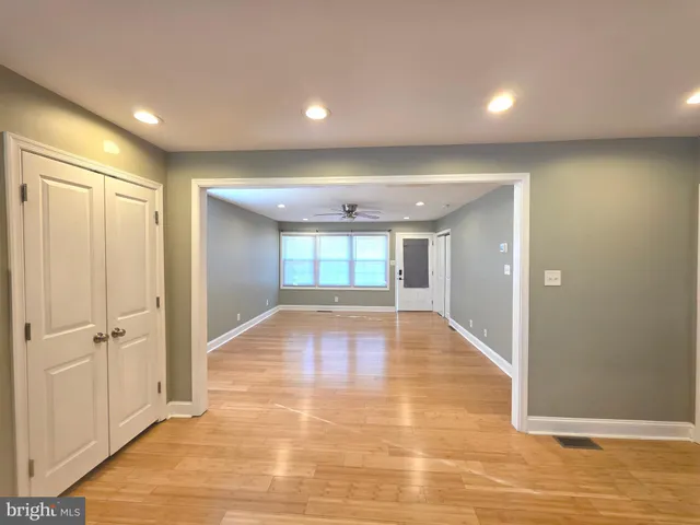an empty room with wooden floor and window
