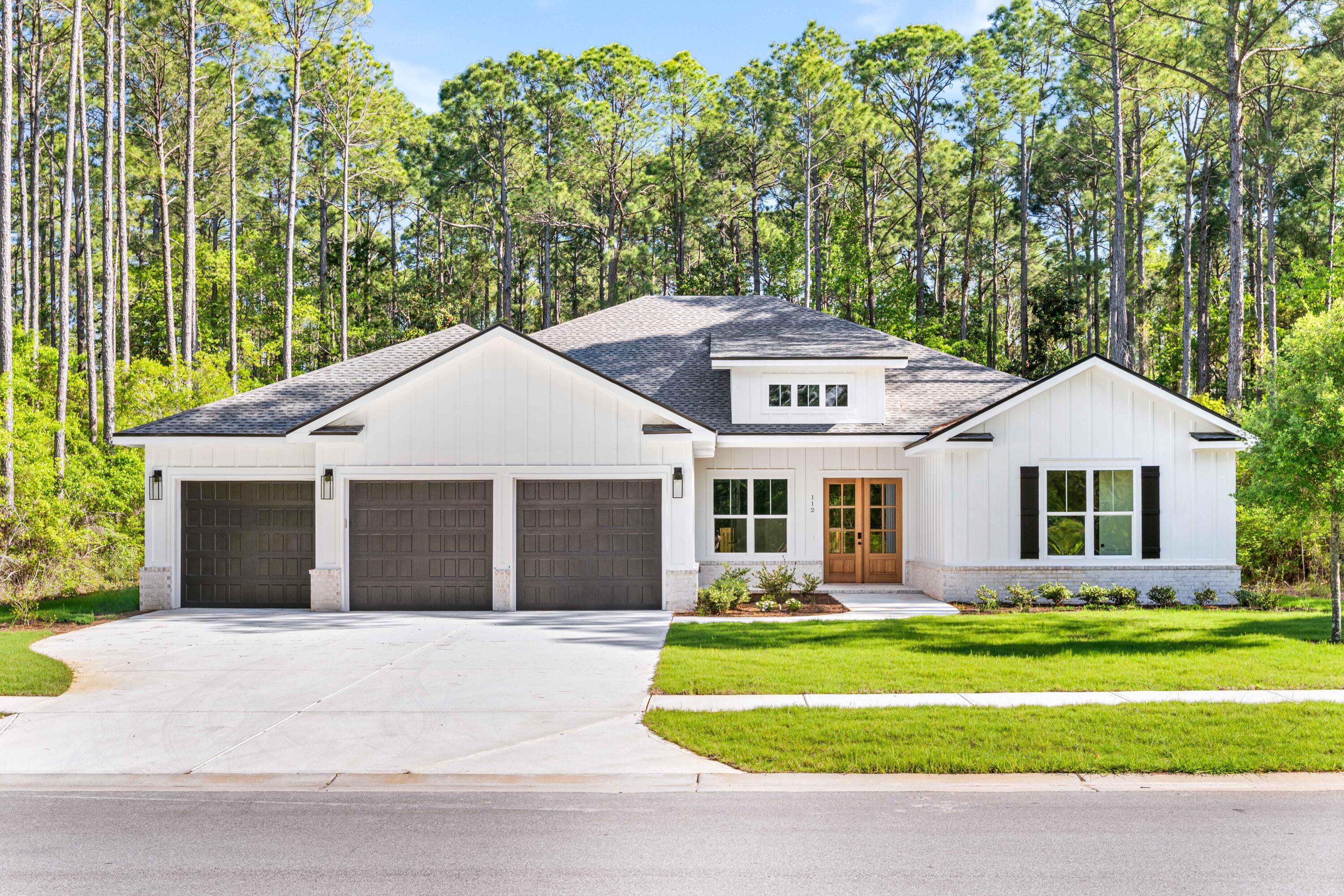 a front view of a house with a garden and trees