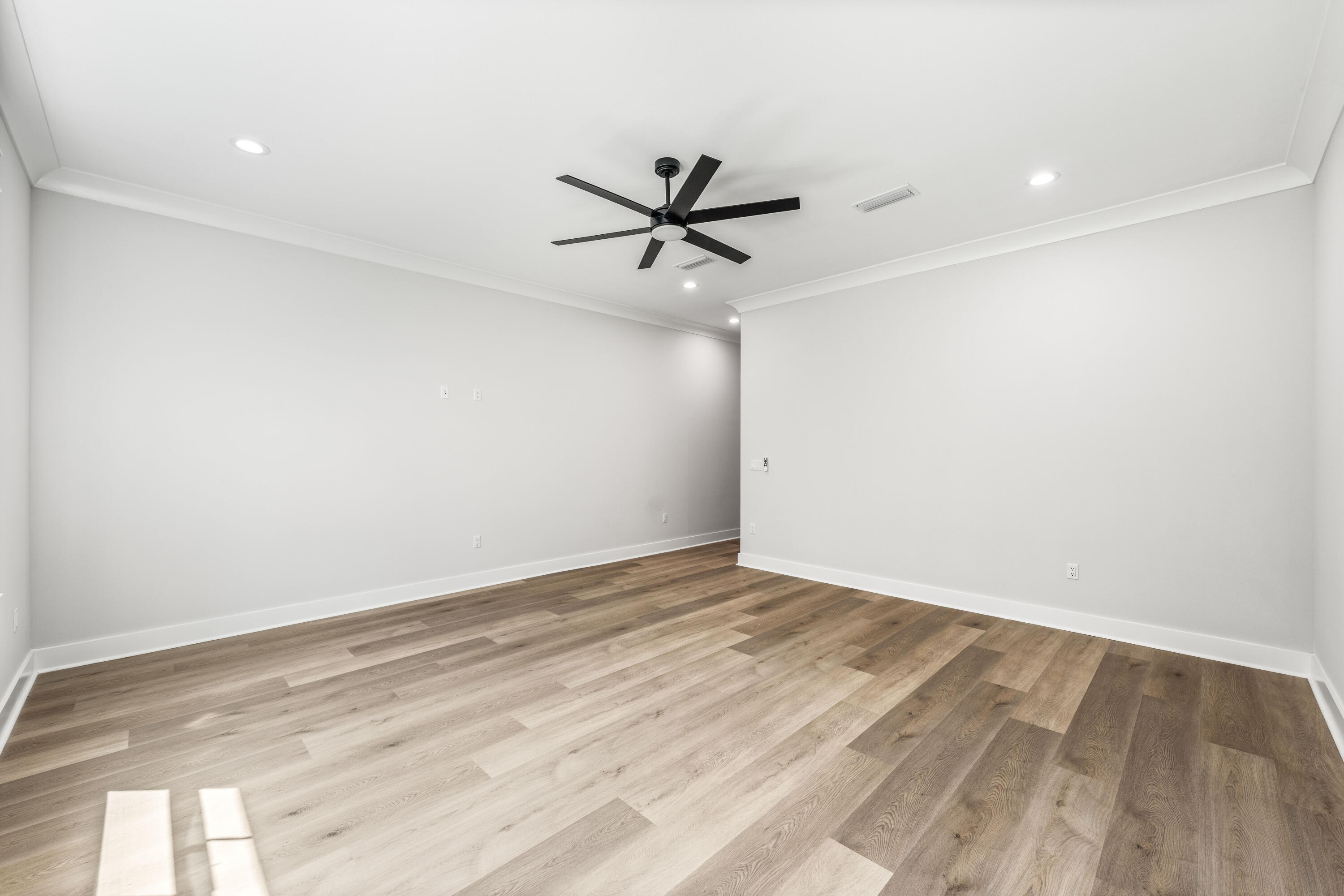 112 East Captain Fritz Way Freeport, FL 32439 - Photo 23 of 114 an empty room with a ceiling fan and wooden floor