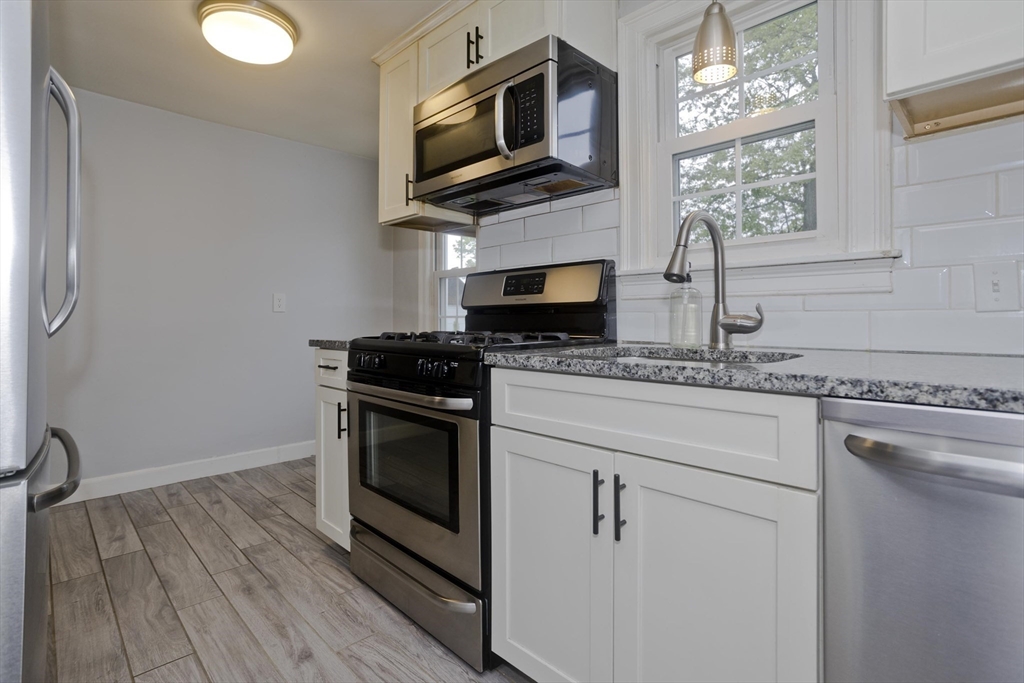 52 Gillette Circle Springfield, MA 01118 - Photo 10 of 30 a kitchen with stainless steel appliances a stove microwave and sink
