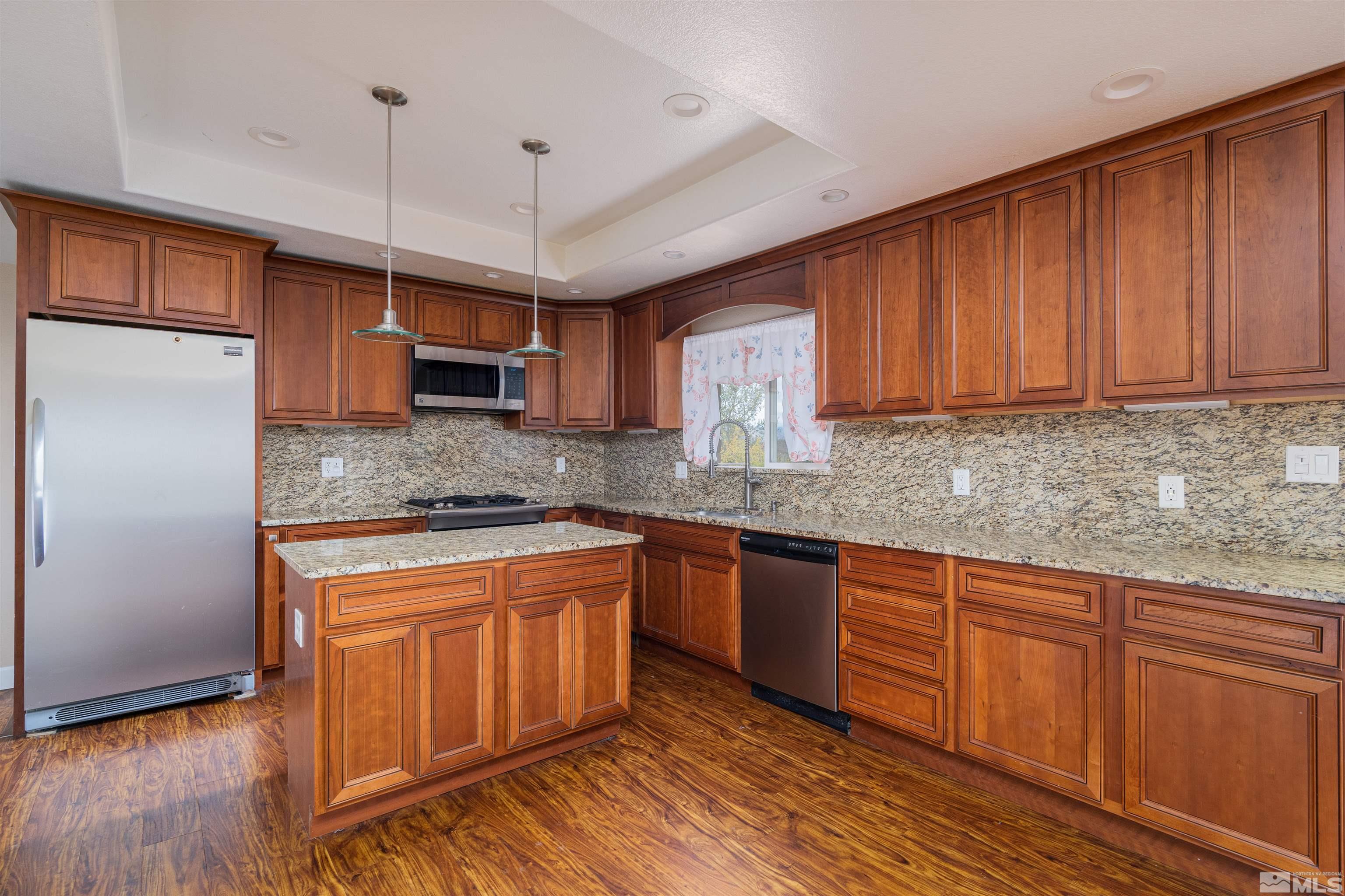5705 Blue Hills Drive Reno, NV 89502 - Photo 3 of 29 a kitchen with stainless steel appliances granite countertop wooden cabinets a refrigerator and a sink