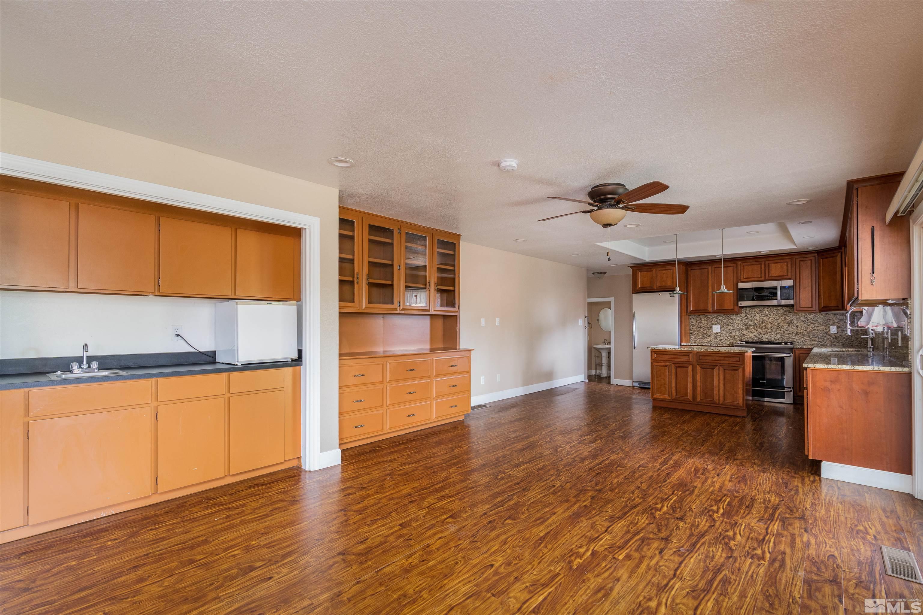5705 Blue Hills Drive Reno, NV 89502 - Photo 5 of 29 a kitchen with stainless steel appliances granite countertop a sink cabinets and wooden floor