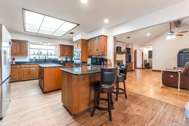a kitchen with stainless steel appliances granite countertop wooden floors a view dining table and chairs