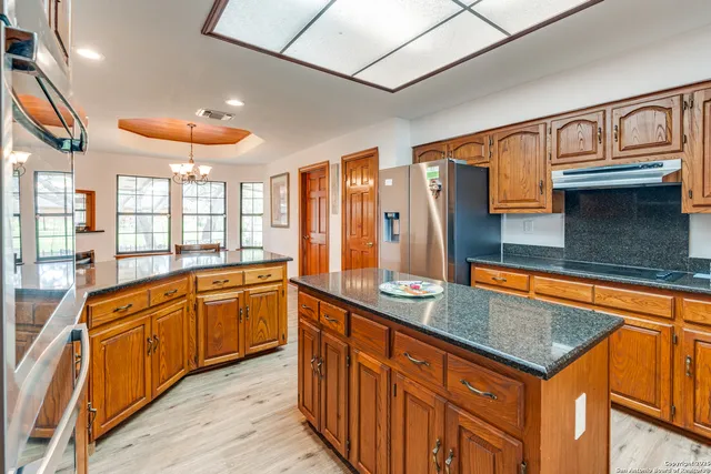 a kitchen with stainless steel appliances granite countertop a sink and a stove