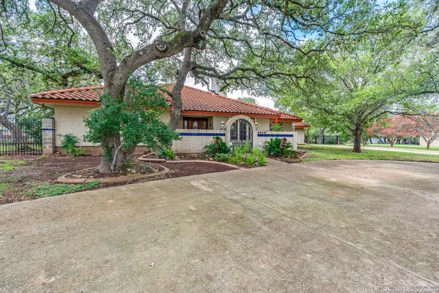 a front view of a house with a yard and potted plants