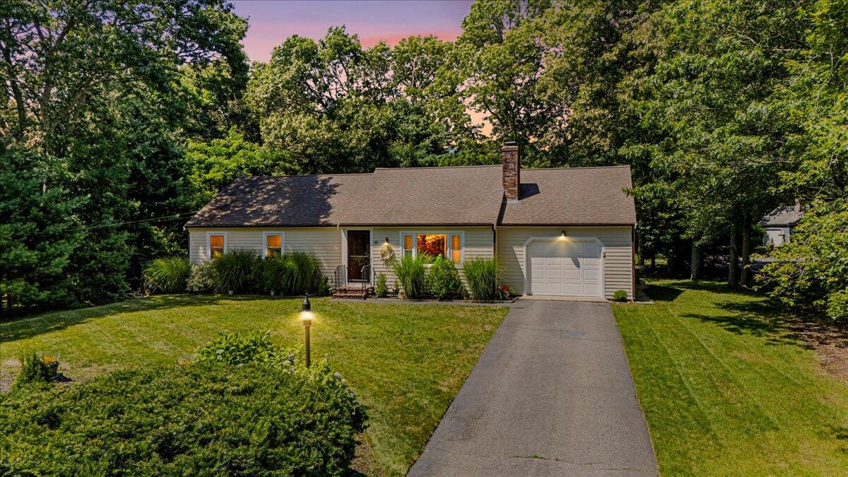 a front view of a house with a yard and trees