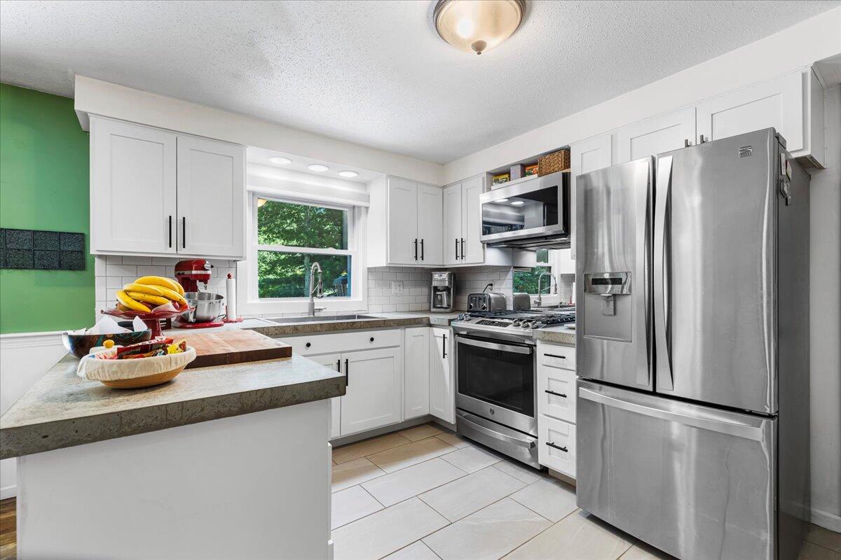 48 Valley Brook Road Centerville, MA 02632 - Photo 16 of 34 a kitchen with stainless steel appliances a refrigerator a stove a sink and a window