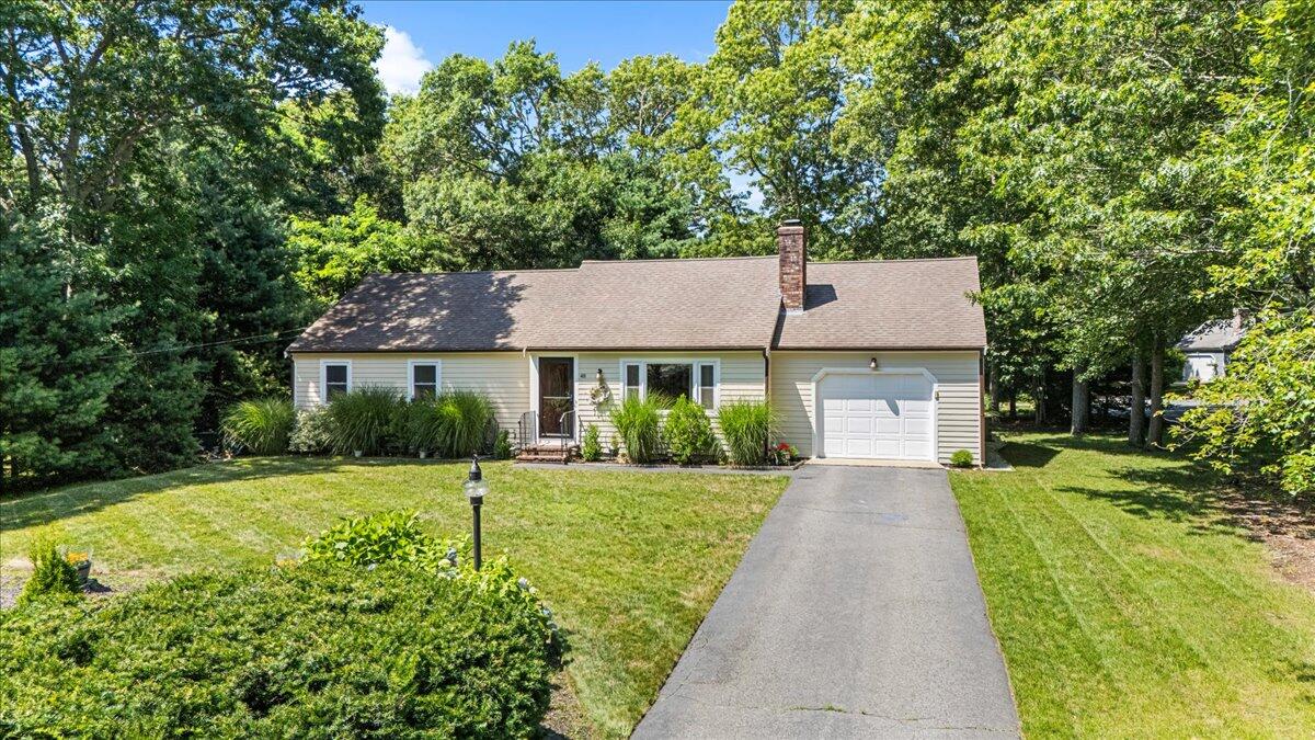 48 Valley Brook Road Centerville, MA 02632 - Photo 2 of 34 a front view of a house with a yard