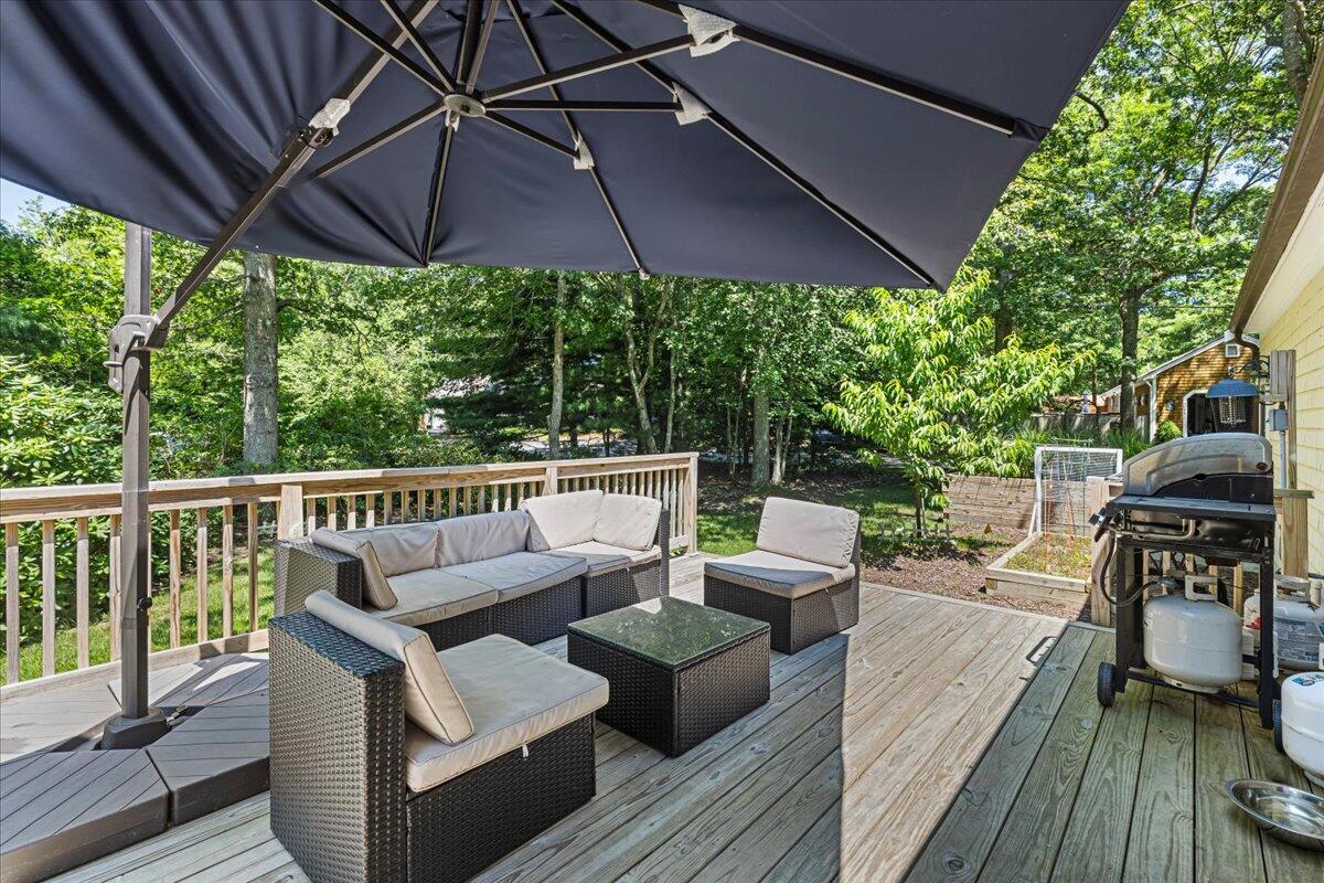 48 Valley Brook Road Centerville, MA 02632 - Photo 9 of 34 a view of a roof deck with couches under an umbrella