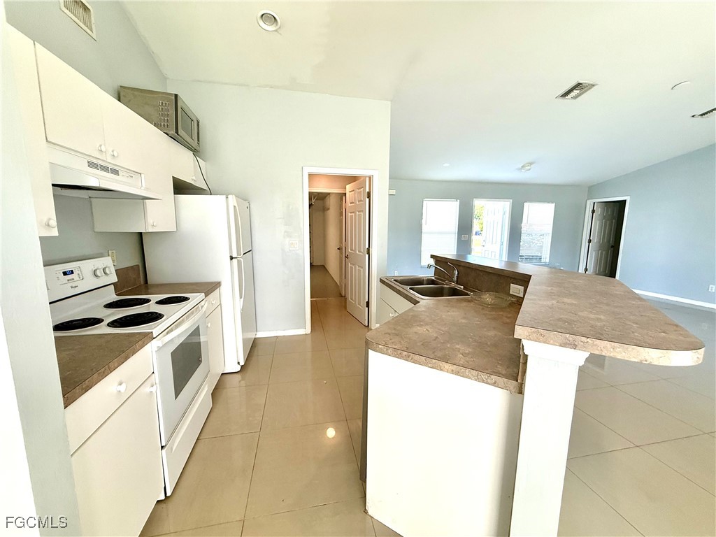 2911 40th Street Southwest Lehigh Acres, FL 33976 - Photo 8 of 22 a kitchen with stainless steel appliances granite countertop a sink and a stove