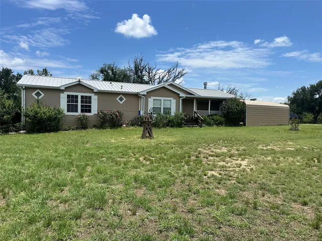 a view of a house with a big yard and potted plants