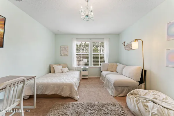 a bedroom with furniture and a large window