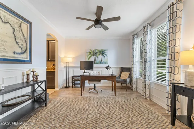 a work room with furniture a rug and a window