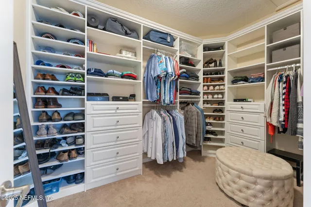 a view of walk in closet with clothes and shoes
