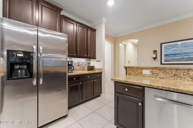 a kitchen with stainless steel appliances granite countertop a refrigerator a sink and dishwasher
