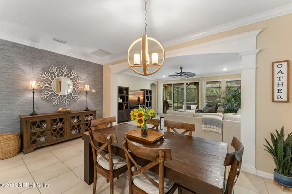 a dining room with wooden floor a chandelier a wooden table and chairs
