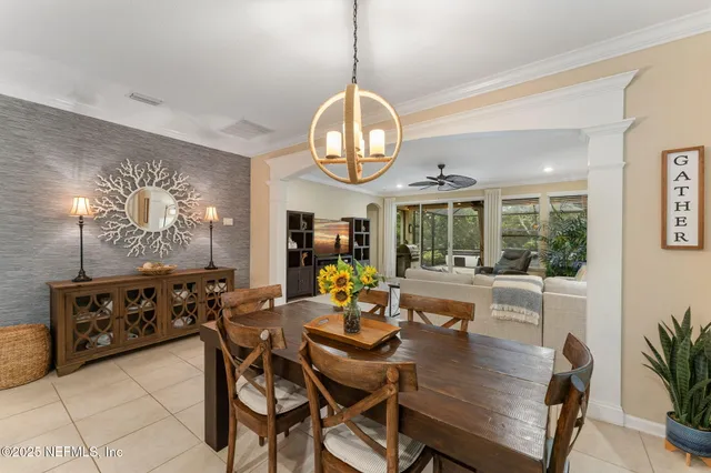 a dining room with wooden floor a chandelier a wooden table and chairs