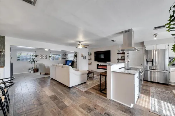 a large kitchen with stainless steel appliances granite countertop a sink stove and refrigerator