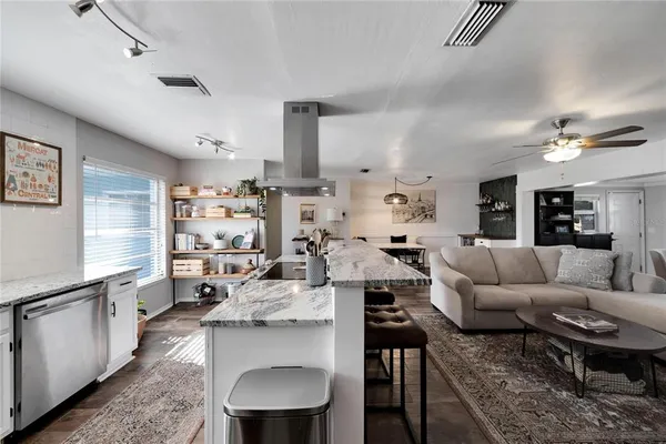 a kitchen sink with granite countertop white cabinets and a sink