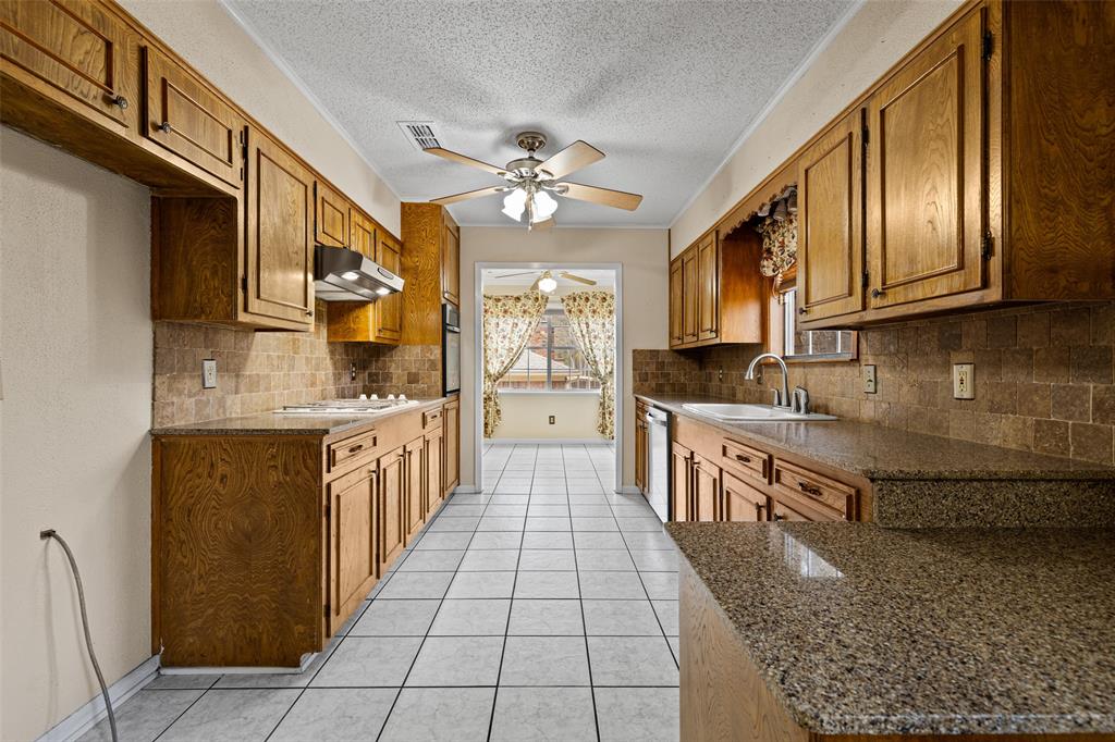 3215 Restview Street Longview, TX 75605 - Photo 14 of 40 a large kitchen with stainless steel appliances granite countertop a stove a sink dishwasher and cabinets