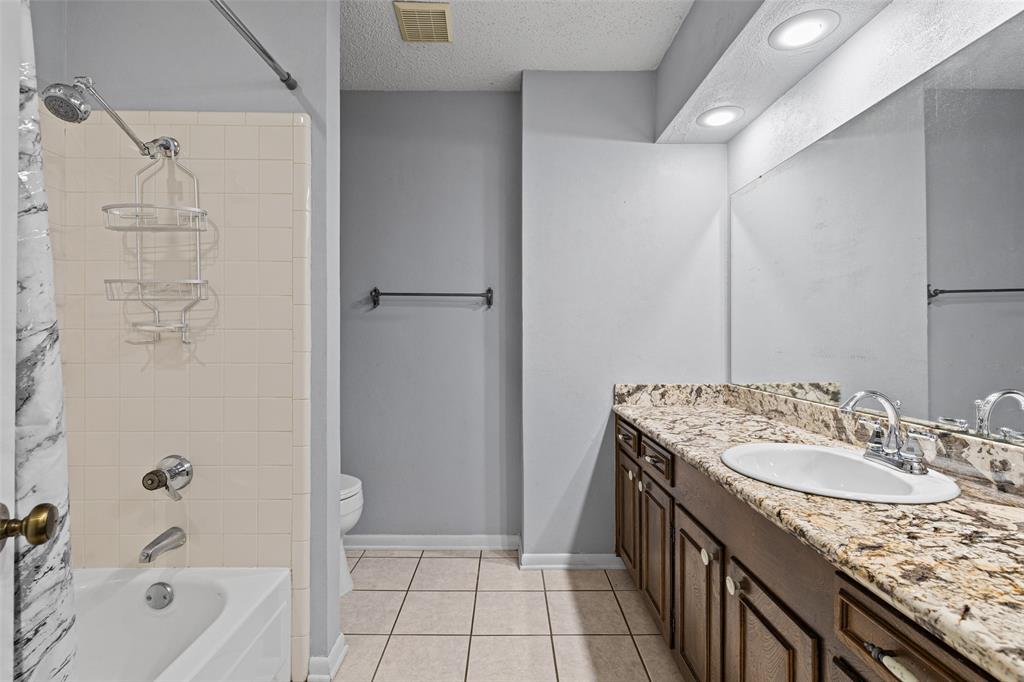 3215 Restview Street Longview, TX 75605 - Photo 22 of 40 a bathroom with a granite countertop sink a mirror and a bathtub