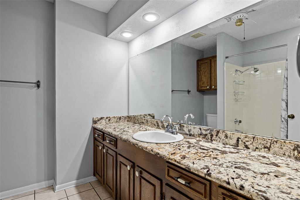 3215 Restview Street Longview, TX 75605 - Photo 23 of 40 a bathroom with a granite countertop sink and a mirror