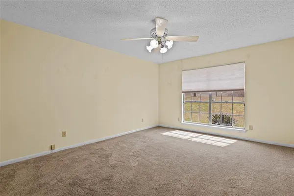 a view of an empty room with a chandelier fan