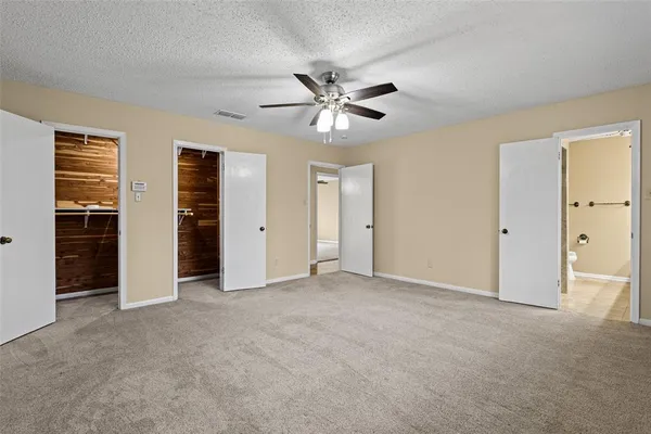 a spacious bathroom with a granite countertop sink a toilet and a mirror