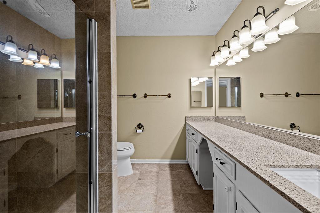 3215 Restview Street Longview, TX 75605 - Photo 30 of 40 a spacious bathroom with a granite countertop sink a toilet and a mirror