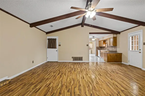 a view of empty room with wooden floor and fireplace