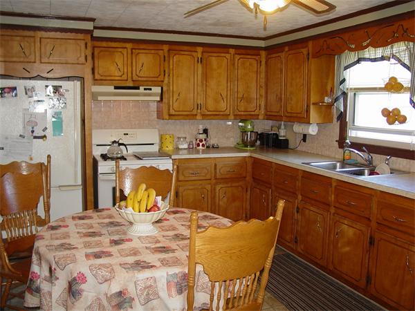 210 4th Street Fall River, MA 02721 - Photo 15 of 27 a kitchen with stainless steel appliances granite countertop a sink a stove a dining table and chairs with wooden floor