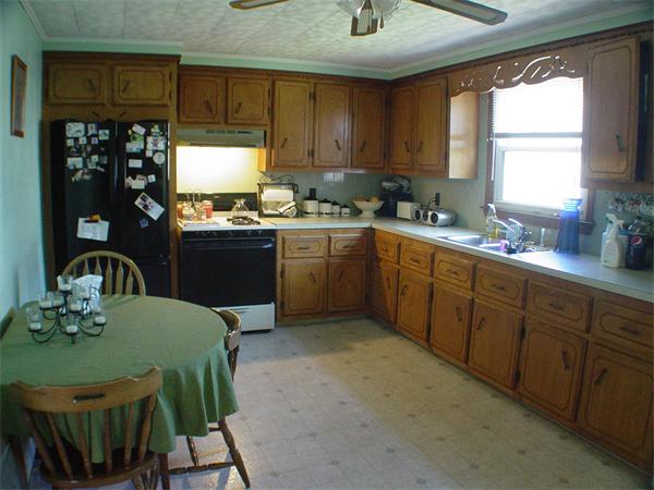 210 4th Street Fall River, MA 02721 - Photo 10 of 27 a kitchen with stainless steel appliances granite countertop a sink dishwasher a stove a refrigerator with a dining table and chairs
