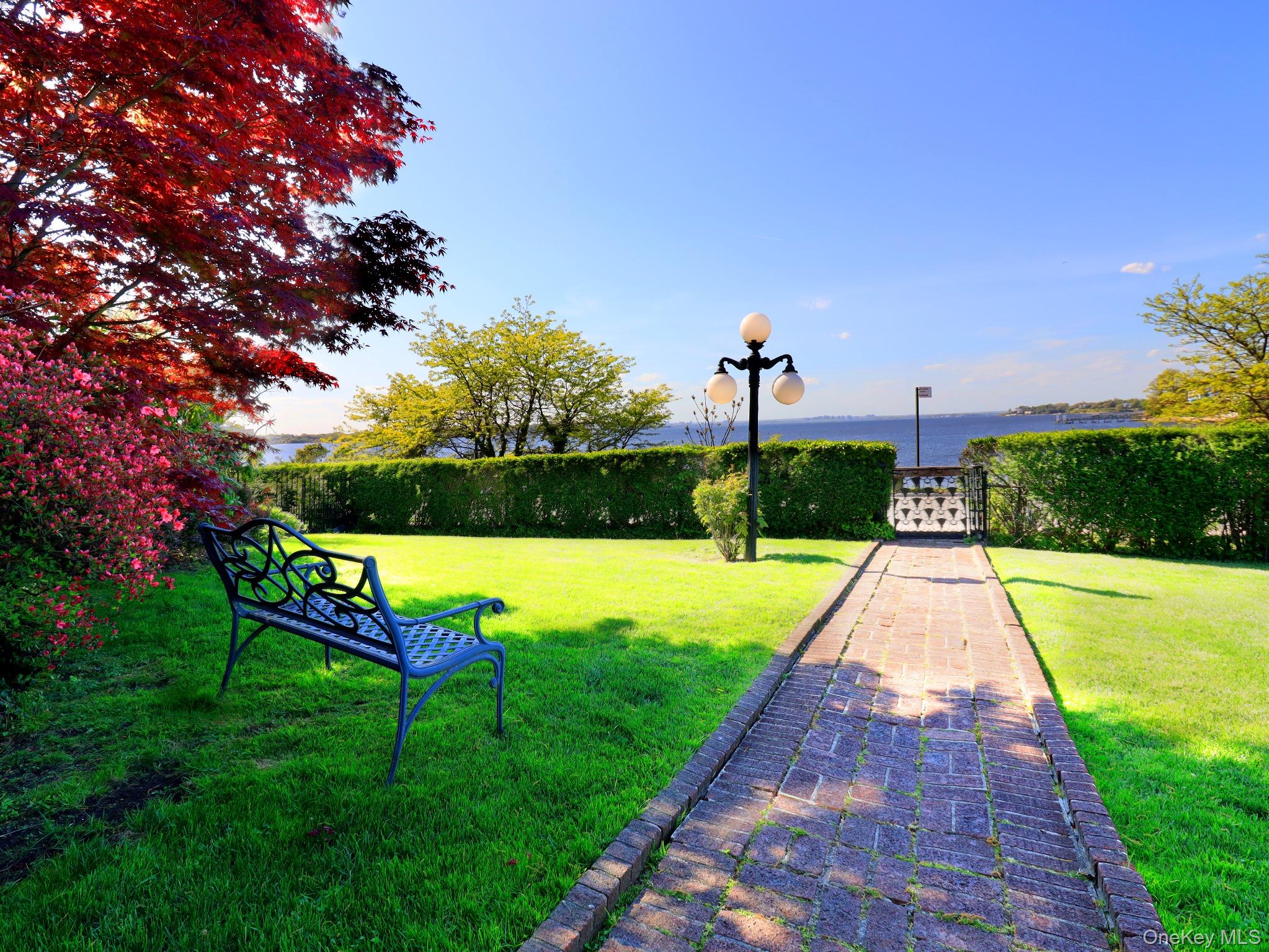 11-20 Shore Road Queens, NY 11363 - Photo 21 of 45 Expansive lawn with a brick pathway leading to a decorative metal gate