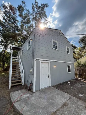 a view of an house with backyard and trees