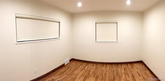 a view of a small space with wooden floor and a window