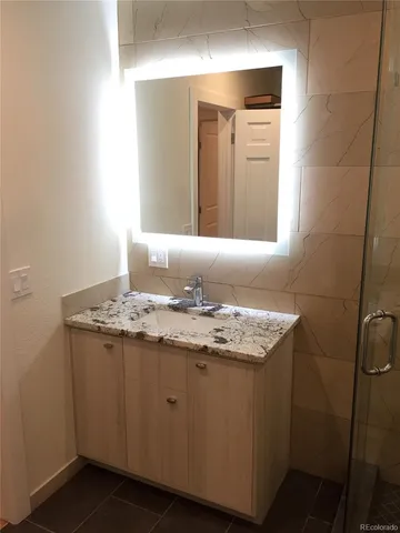 a bathroom with a granite countertop sink and a mirror