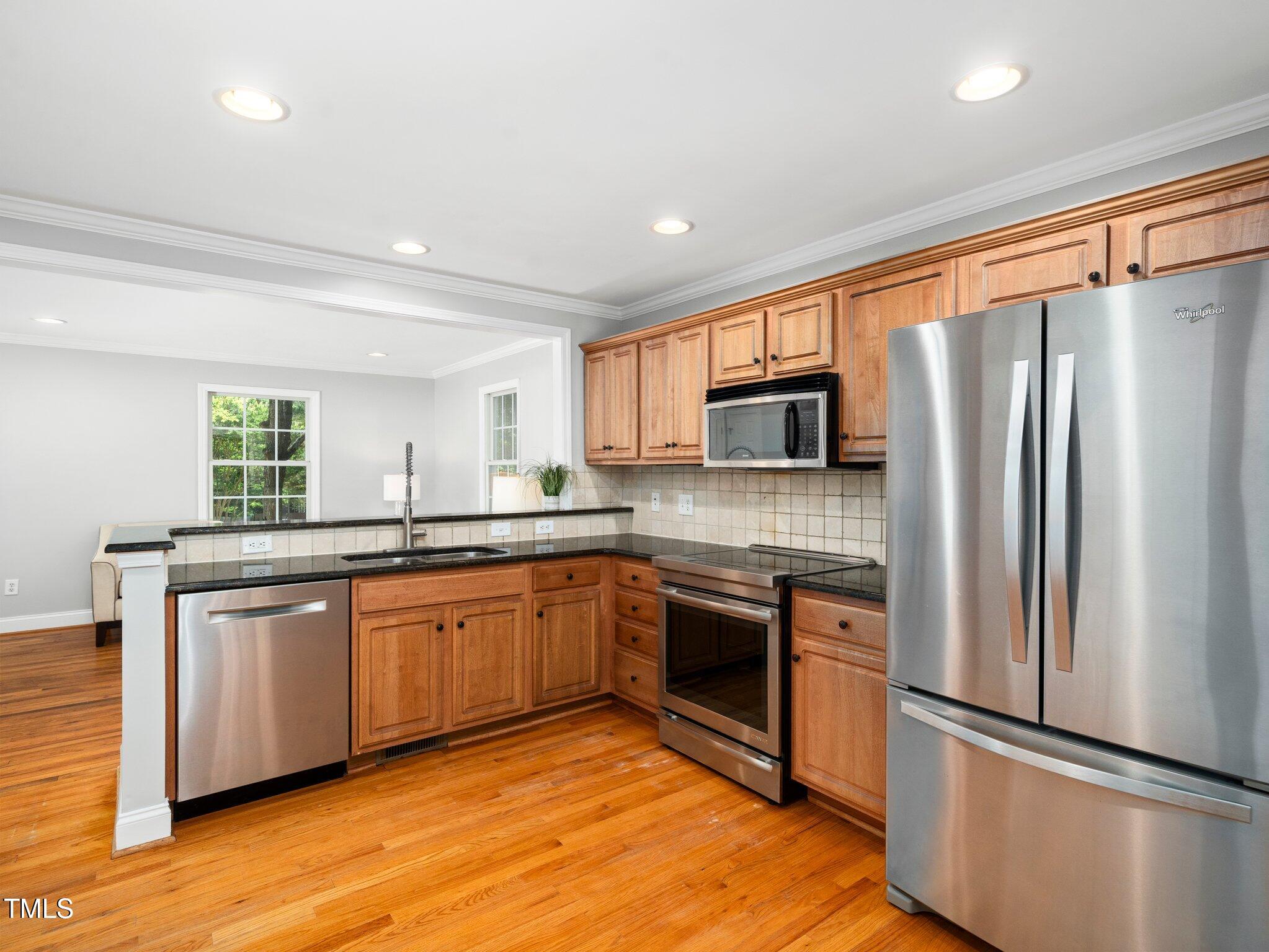 1825 Watkins Street Raleigh, NC 27604 - Photo 9 of 27 a kitchen with stainless steel appliances granite countertop a refrigerator a stove top oven a sink and dishwasher