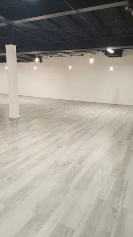 a living room with stainless steel appliances kitchen island a table and chairs in it