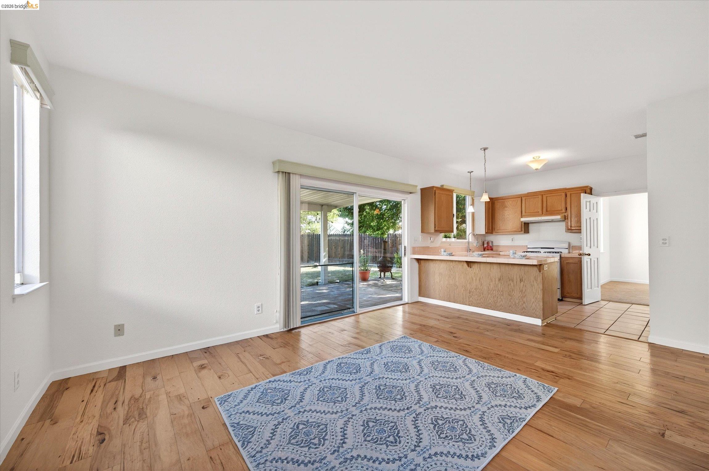 1120 Deerpark Road Oakley, CA 94561 - Photo 12 of 30 Open concept living area featuring wood-finish flooring, white walls, and a sliding glass door to the backyard