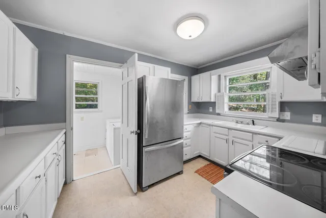 a kitchen with a refrigerator sink and cabinets
