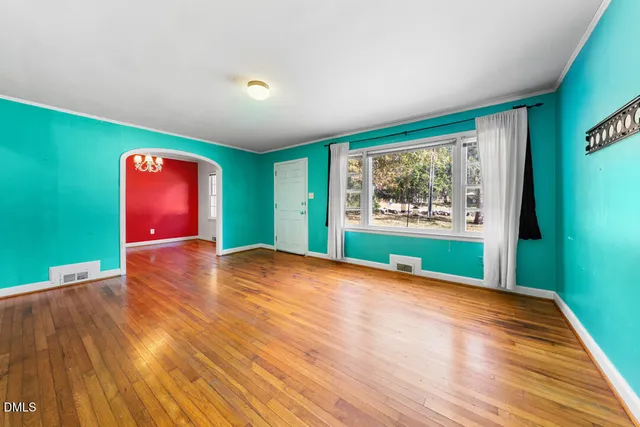 a view of an empty room with window wooden floor