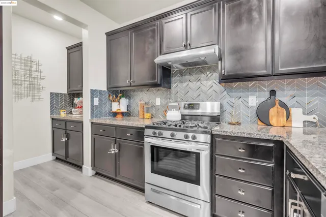 a kitchen with stainless steel appliances granite countertop a stove and a cabinets