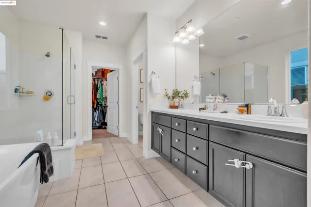 a spacious bathroom with a double vanity sink mirror and shower