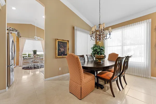 a dining room with furniture a chandelier and wooden floor