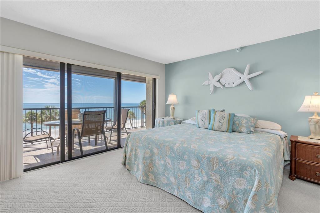 14950 Gulf Boulevard, Unit 402 Madeira Beach, FL 33708 - Photo 12 of 36 a bedroom with a large bed and a large window