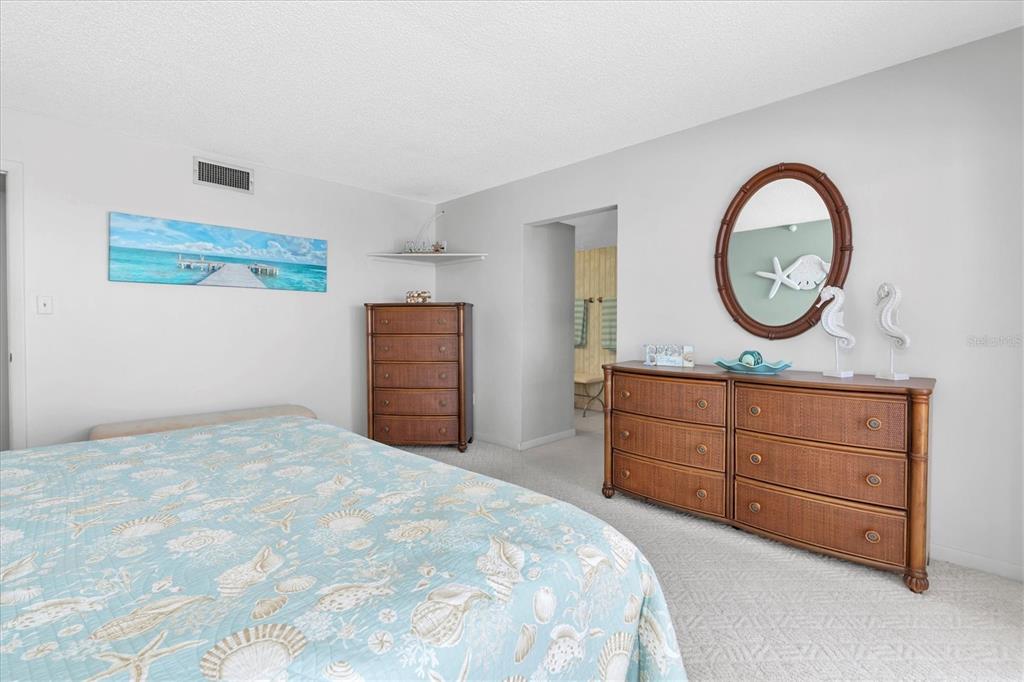 14950 Gulf Boulevard, Unit 402 Madeira Beach, FL 33708 - Photo 13 of 36 a bedroom with a bed and a dresser