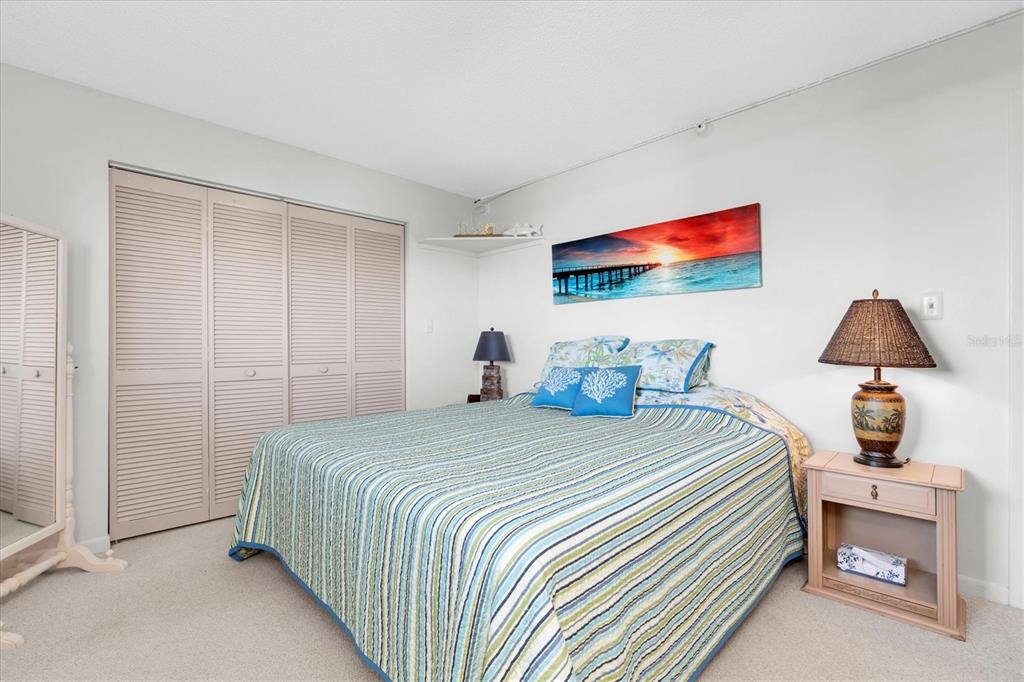 14950 Gulf Boulevard, Unit 402 Madeira Beach, FL 33708 - Photo 17 of 36 a bedroom with a bed and a lamp