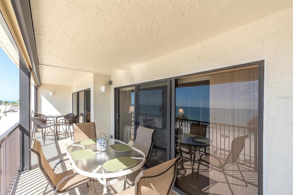 14950 Gulf Boulevard, Unit 402 Madeira Beach, FL 33708 - Photo 23 of 36 a dining room with furniture a table and chairs