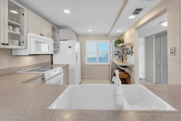 a living room with stainless steel appliances furniture a rug and a refrigerator